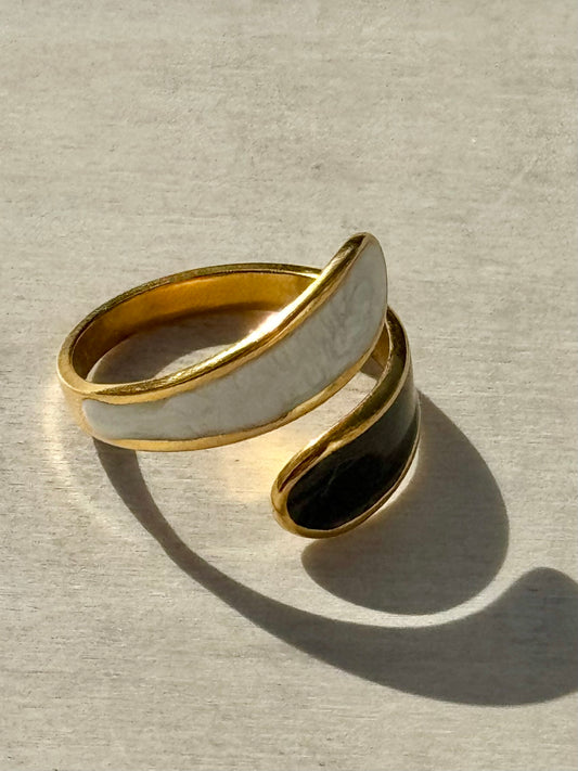 Gold and black ring on a textured beige surface