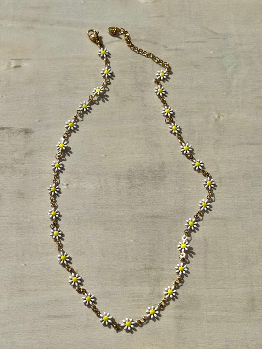 Necklace with daisy flower pendants on a textured surface