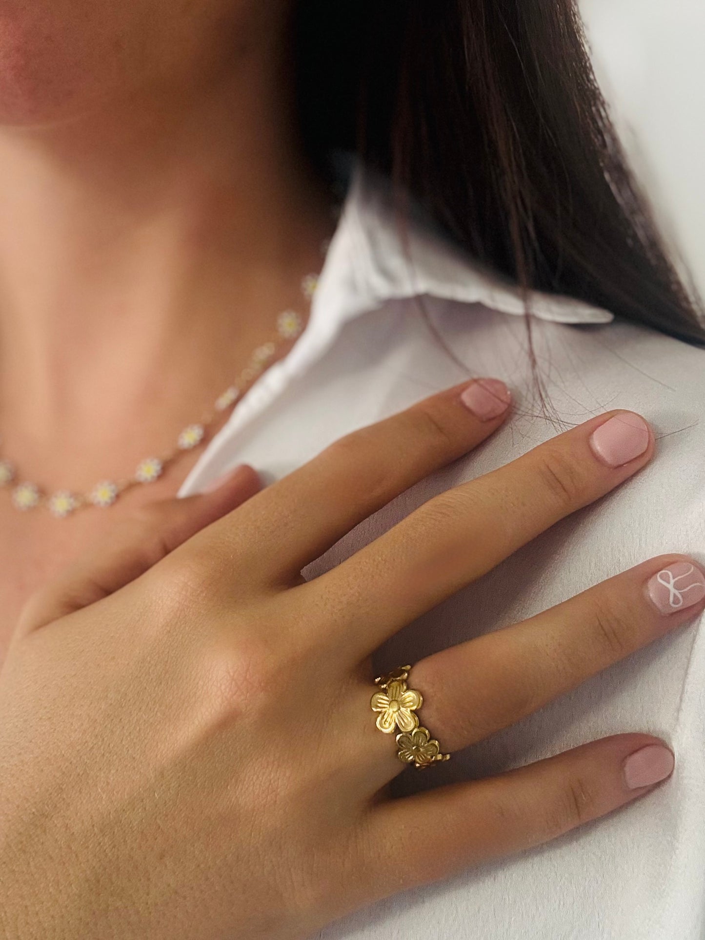 Hand wearing a gold ring with a white background