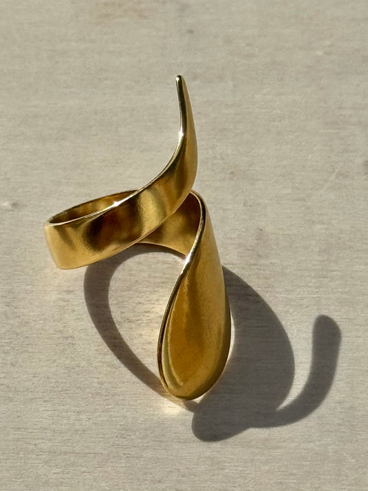 Gold bracelet on a light gray background