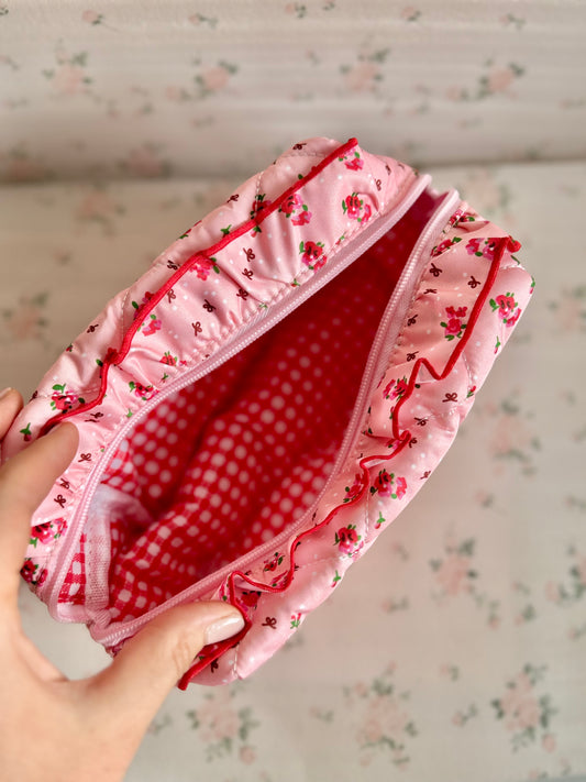 Floral-patterned fabric with a checkered lining held by a hand on a floral background