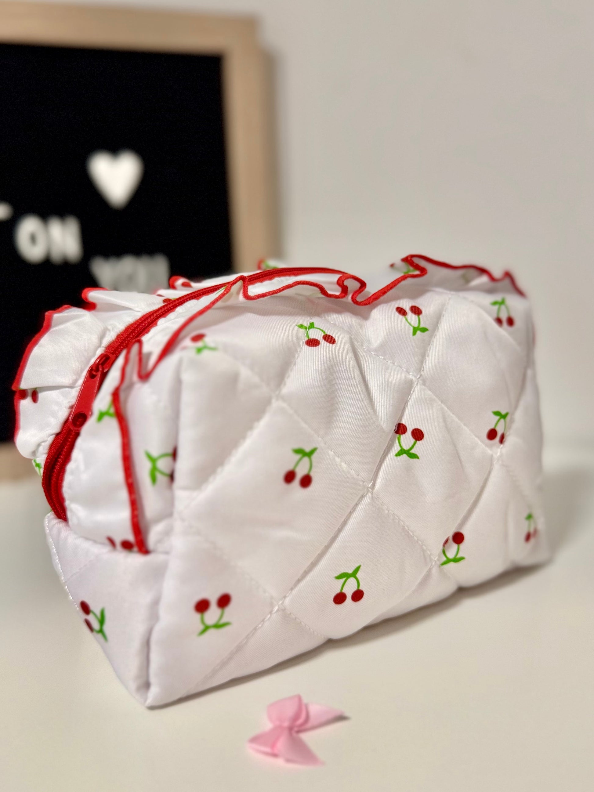 Quilted white tissue box cover with red and green accents on a light surface.