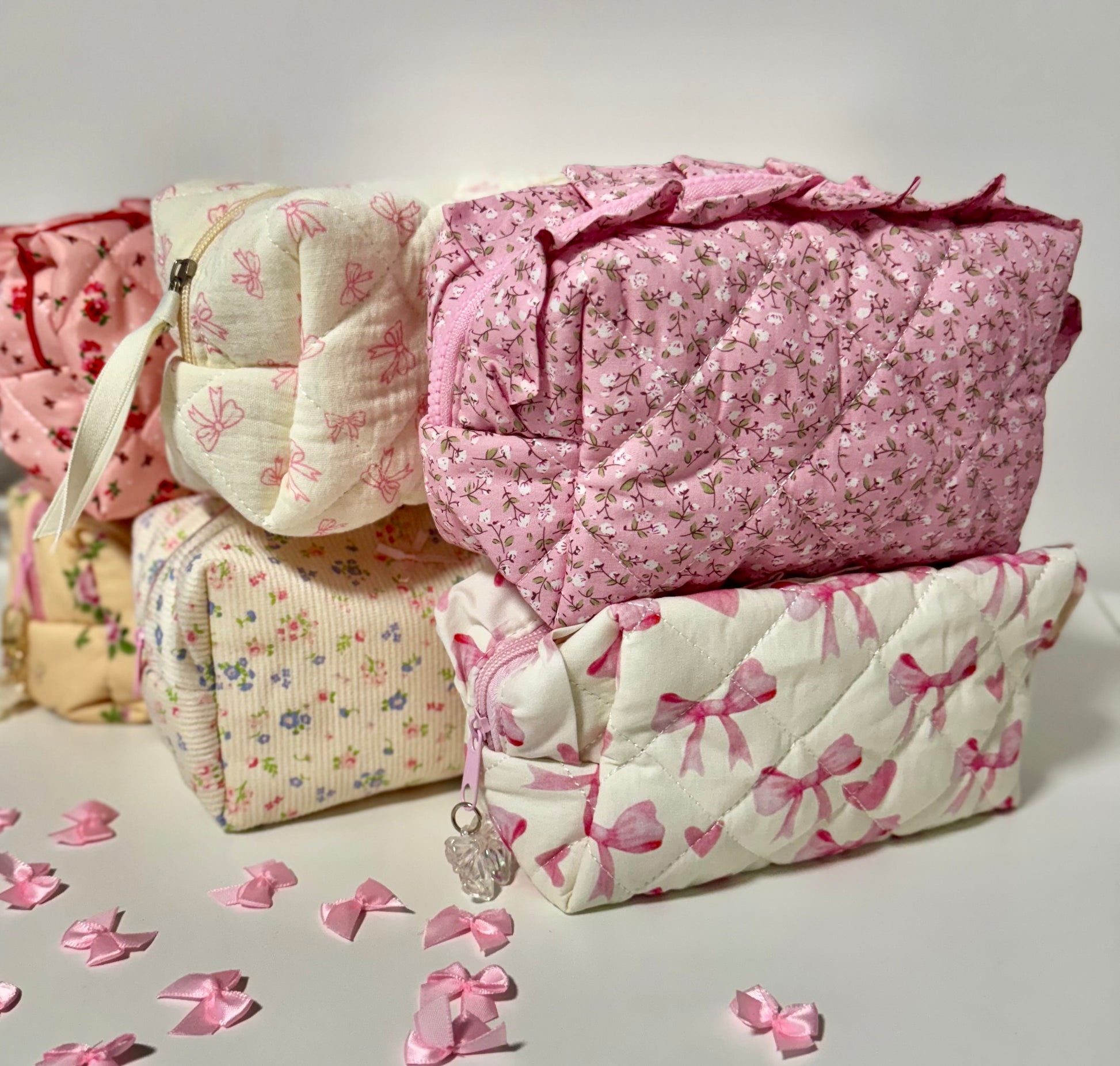 Stack of quilted fabric pieces with floral and bow patterns on a light background