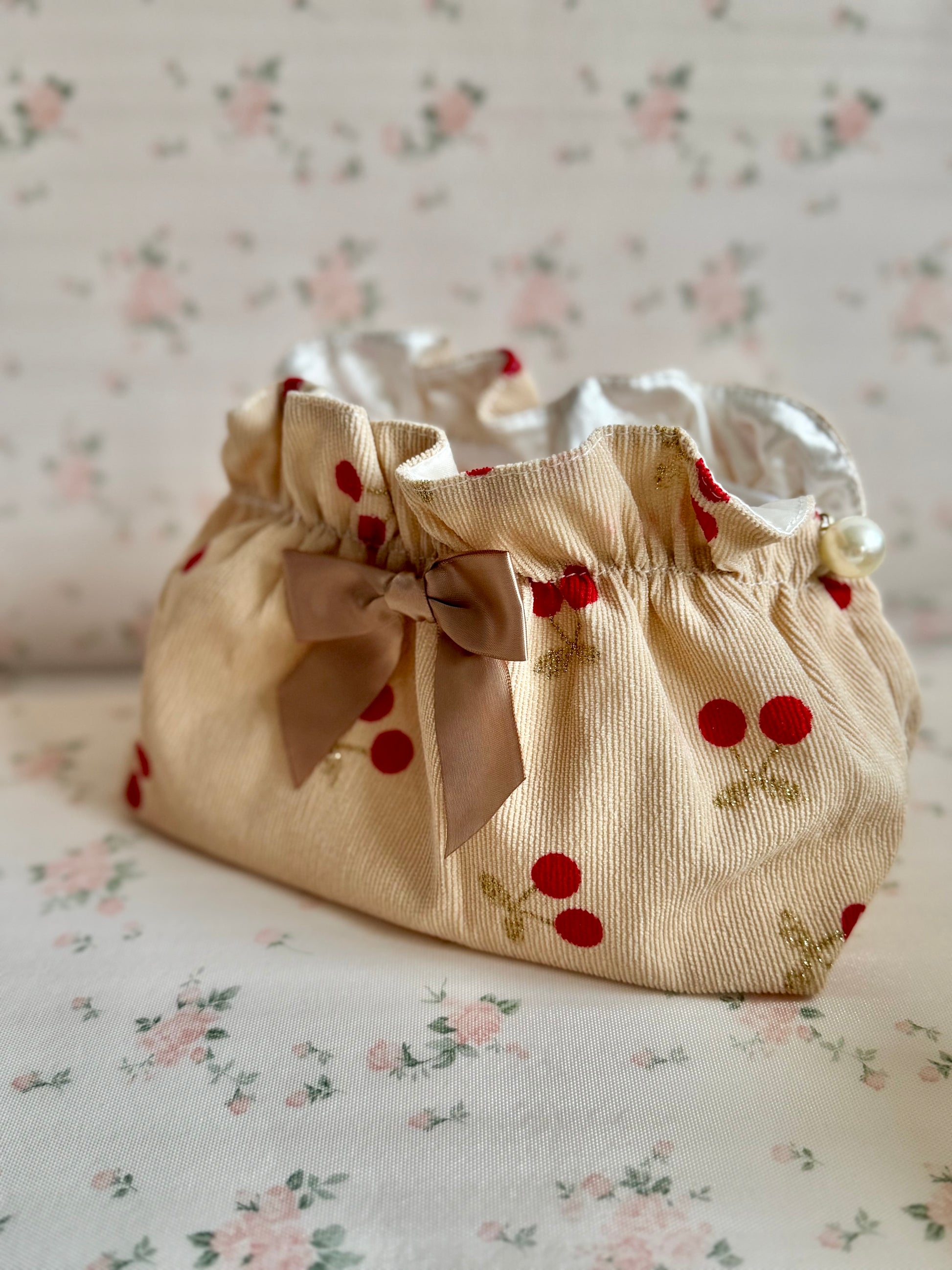 Fabric bag with cherry pattern on a floral background