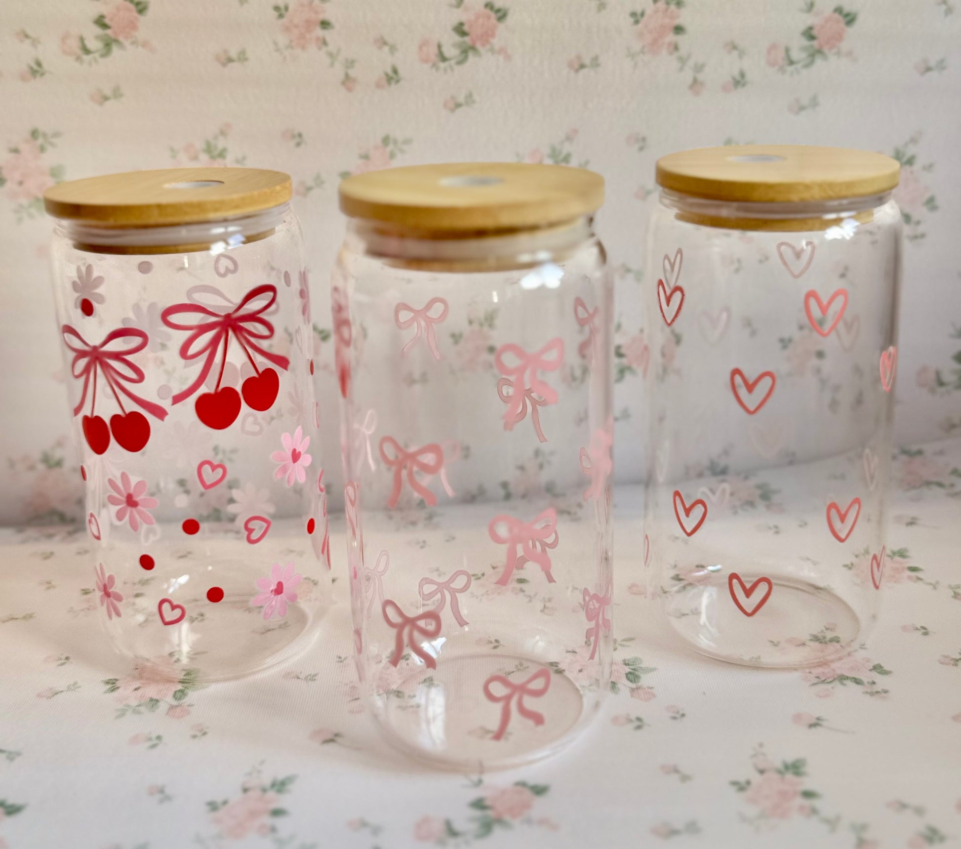 Three glass jars with wooden lids on a floral-patterned surface